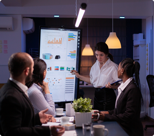 Team discussing numbers and flow in front of a presentation board