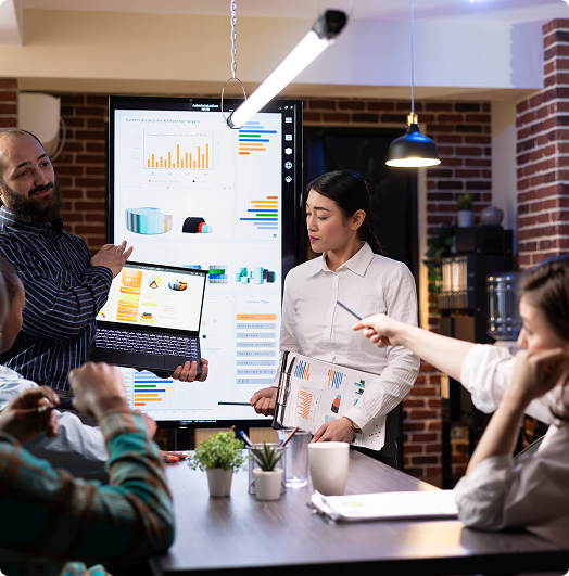 Team discussing numbers and flow in front of a presentation board