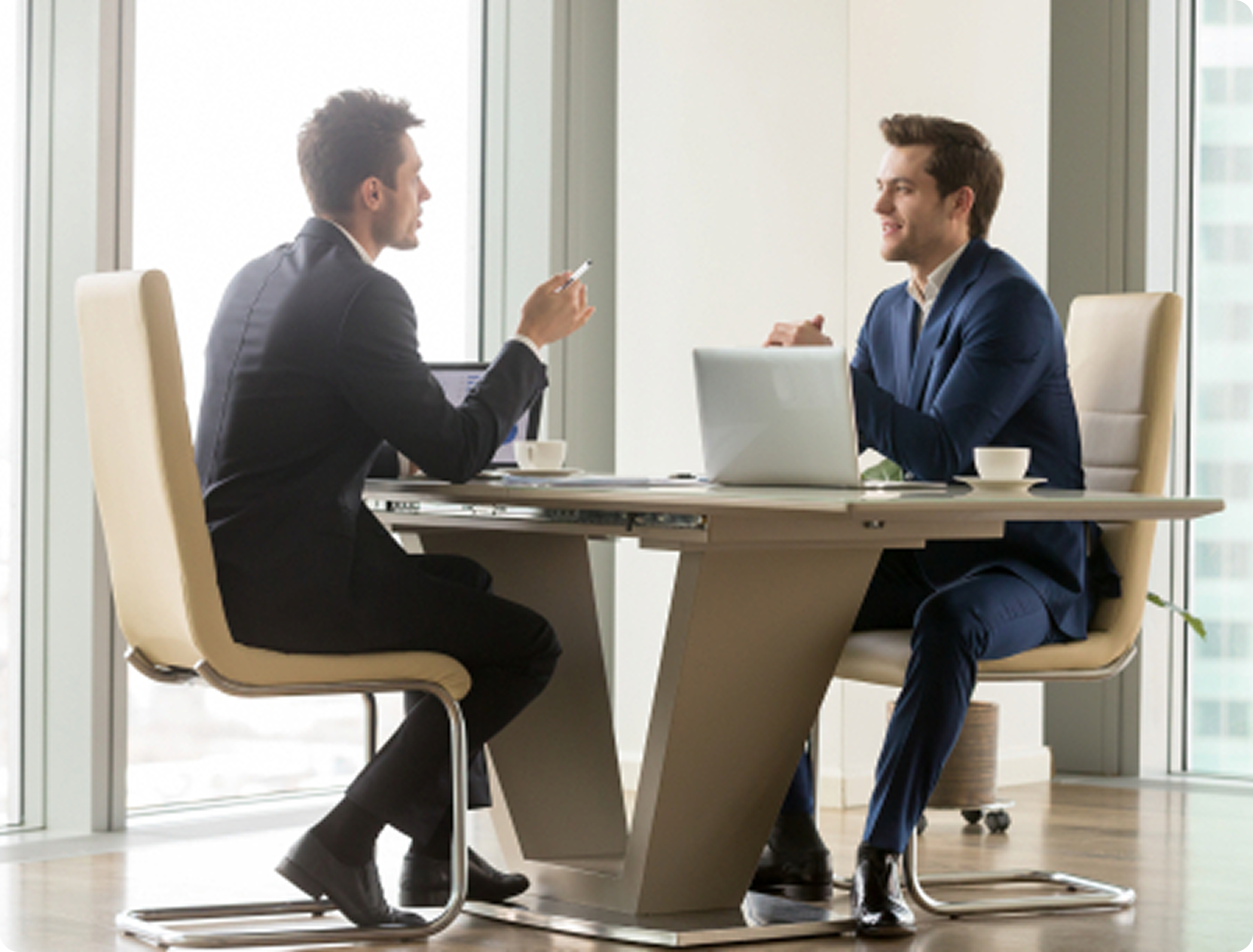 Two business professionals having strategic discussion at meeting table